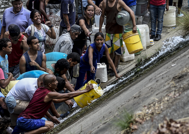 11일(현지시간) 베네수엘라 수도 카라카스에서 주민들이 식수를 구하기 위해 모여있다. /카라카스=AFP연합뉴스