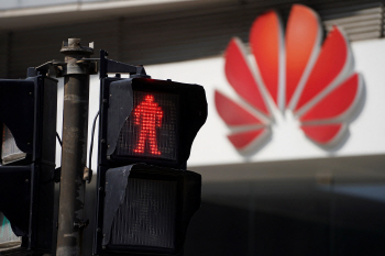 지난 7일(현지시간) 중국 상하이 시내에서 적색 신호등 뒤로 화웨이 로고가 보이고 있다. /상하이=로이터연합뉴스