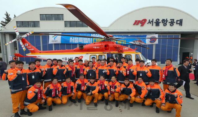 서울소방재난본부 다목적 소방헬기 취항식에 참석한 박원순 서울시장과 소방공무원들이 12일 김포공항 서울항공대에서 주먹을 쥐어 올리고 있다. 다목적 소방헬기에는 각종 의료 장비가 실려 있어 /이호재기자