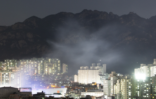 13일 서울 은평구 모델하우스에서 발생한 화재의 불씨가 옮겨 붙은 것으로 추정되는 북한산 일대에 연기가 나고 있다. /연합뉴스