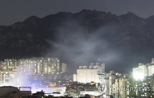 13일 서울 은평구 모델하우스 화재의 불씨가 옮겨붙은 북한산 일대에서 야간 화재 진압작업이 진행되고 있다./연합뉴스