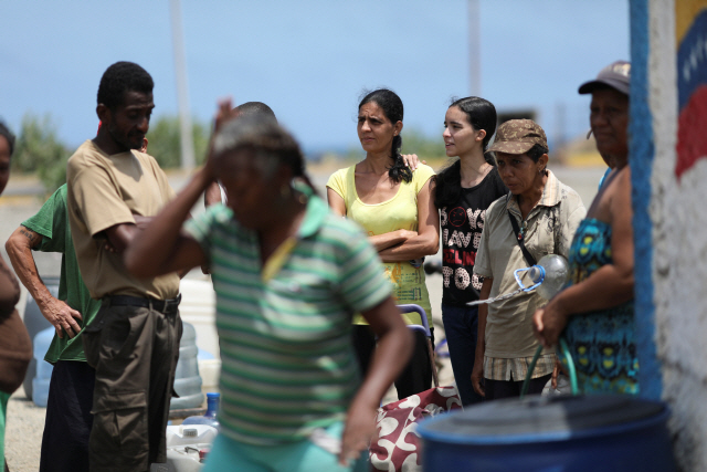 대규모 정전사태로 일대 혼란을 겪고 있는 베네수엘라 북부 과이라 주민들이 식수를 얻기 위해 모여 있다. /과이라=로이터연합뉴스