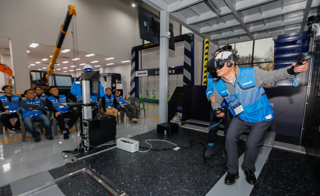 대림산업 임원이 VR 장비를 착용하고 고소작업을 체엄하고 있다./사진=대림산업