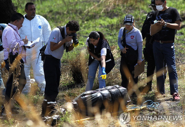 훼손된 시신이 들 것으로 추정되는 비닐봉지가 대량으로 발견된 현장/AFP=연합뉴스