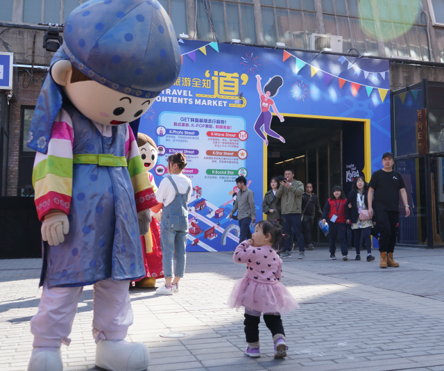 “반가워요 한국관광”…16일 베이징 798예술구에서 진행된 ‘방한관광 콘텐츠 페스티벌’을 가족과 함께 방문한 한 중국인 아이가 한국관광공사 마스코트인 초롱이를 바라보고 있다.