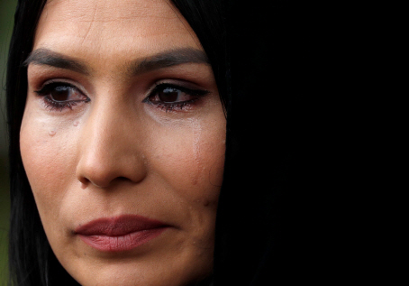 히잡을 두른 한 여성이 17일(현지시간) 뉴질랜드 크라이스트처치의 마스지드 알 누르 이슬람사원(모스크) 인근에 설치된 추모소에서 눈물을 흘리고 있다. /크라이스트처치=로이터연합뉴스