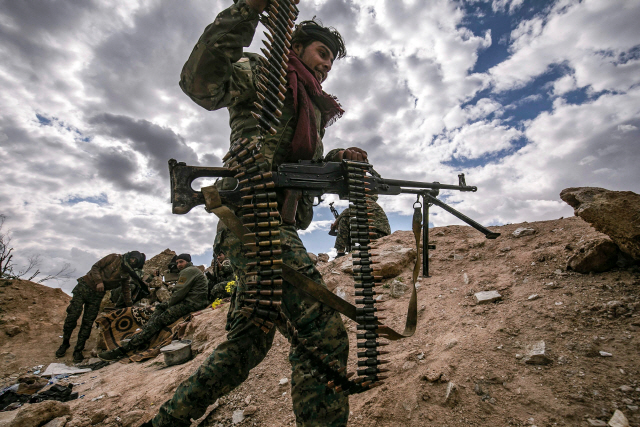 미군 지원으로 IS(이슬람국가)와 전투를 벌이고 있는 쿠르드·아랍연합 ‘시리아민주군’(SDF)의 대원이 총기를 들고 IS의 마지막 보루라 일컫는 바고우즈를 지나고 있다. /AFP연합뉴스