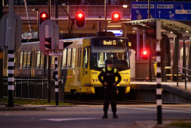18일(현지시간) 네덜란드 중부 도시 위트레흐트의 총격 사건이 발생한 트램 앞에서 경찰이 경계근무를 하고 있다. /위트레흐트=AFP연합뉴스