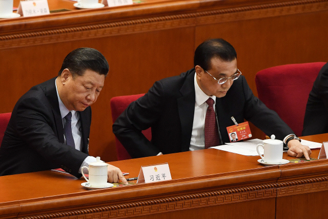 지난 15일 전국인민대표대회에서 시진핑(왼쪽) 중국 국가주석과 리커창 총리가 ‘외상투자법’에 찬성하는 버튼을 누르고 있다. 외상투자법은 이날 투표에서 2,929명이 찬성, 반대·기권 각각 8표로 통과됐다.  /베이징=AFP연합뉴스