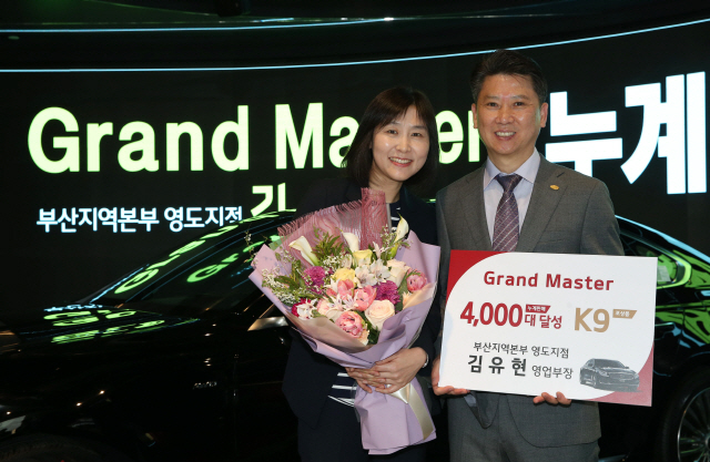 누계 판매 4,000대를 달성한 ‘그랜드 마스터’ 김유현(오른쪽) 기아자동차 부산 영도지점 영업부장이 20일 아내와 기념촬영을 하고 있다. /사진제공=기아자동차