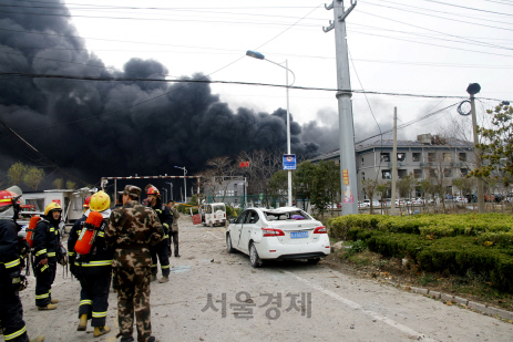 21일(현지시간) 대형 폭발이 일어난 중국 장쑤성 옌청시의 화공공단에서 거대한 검은 연기가 피어오르는 가운데 구조대가 구조 작업을 벌이고 있다.   /옌청=로이터연합뉴스