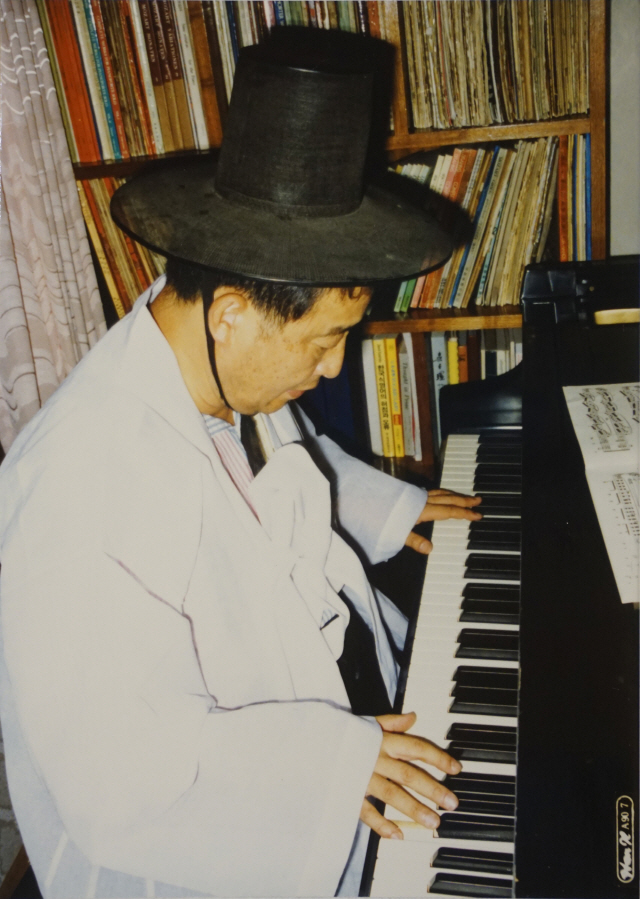 1990년 7월에 동료인 요셉 보이스를 추모하는 진혼굿 퍼포먼스를 준비하며 한복을 입고 피아노 앞에 앉은 백남준. 그는 피아노를 전공했다. /사진제공=박영덕