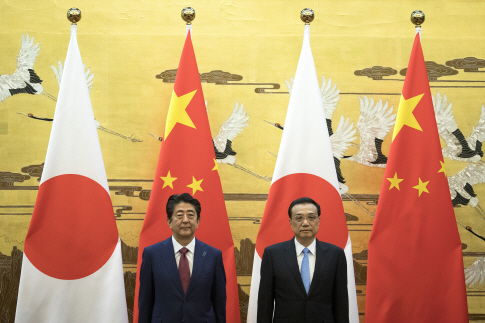 아베 신조(왼쪽) 일본 총리가 리커창 중국 총리와 지난해 10월26일 중국 베이징 인민대회당에서 기념촬영을 하고 있다. 아베 총리는 일본 총리로는 7년여 만에 처음으로 중국을 방문했다.    /베이징=블룸버그