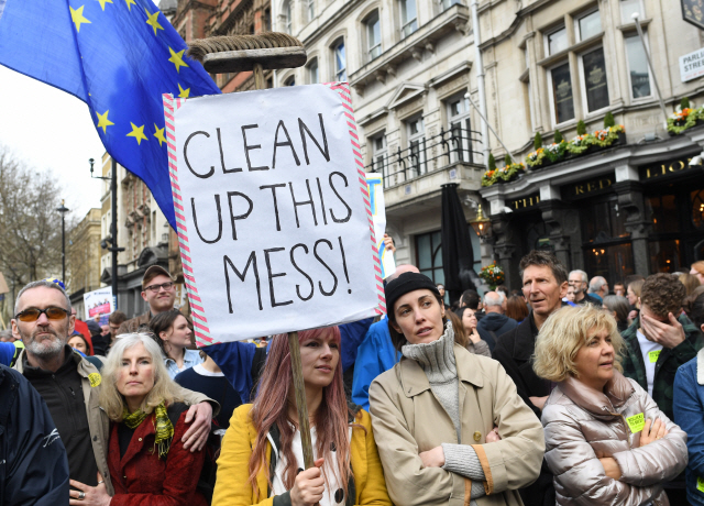 23일(현지시간) 영국 런던 의회광장 앞에서 ‘이 혼란을 수습하라(Clean up this mess)’는 푯말을 든 한 여성과 시민들이 브렉시트(영국의 유럽연합 탈퇴, Brexit)정국을 수습하고자 ‘제2 국민투표’를 요구하는 집회를 벌이고 있다./런던=EPA연합뉴스