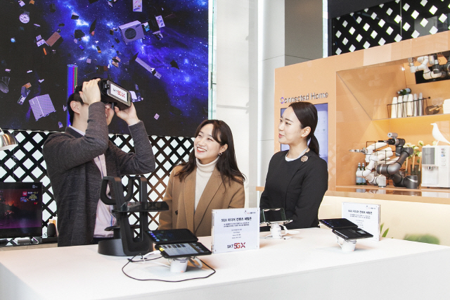SK텔레콤 직원들이 25일 서울 을지로 본사 1층에서 5세대(5G) 상용망과 연결된 ‘갤럭시S10 5G’로 여러 서비스를 체험하고 있다./사진제공=SK텔레콤