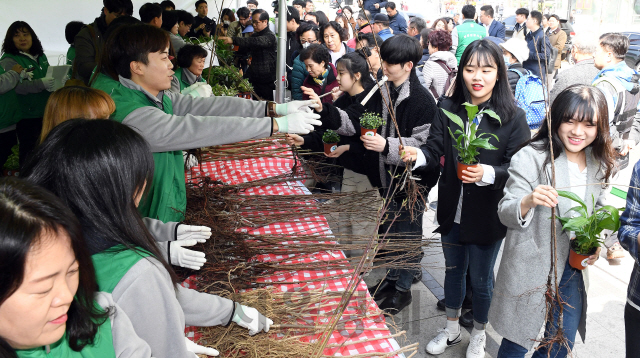 26일 오전 서울 청계광장에서 열린 2019 희망의 나무 나누기' 행사에서 대상 임직원과 자원봉사자들이 시민들에게 나무를 나눠주고 있다. 올해 14회째를 맞은 2019 희망의 나무 나누기 행사는 대상과 한국산림복지진흥원이 매년 식목일을 앞두고 진행하는 행사로 고무나무, 테이블야자, 호야 등 공기정화식물과 매실나무, 앵두나무, 산수유나무 묘목 등 총 15종 4천 그루를 시민들에게 2종씩 무료로 제공한다./이호재기자. 2019.03.26