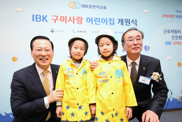 26일 경북 구미에서 열린 ‘IBK 구미사랑 어린이집 개원식’에서 김도진(왼쪽 끝) 기업은행장과 장세용(오른쪽 끝) 구미시장이 어린이들에게 선물을 전달하고 있다./사진제공=기업은행