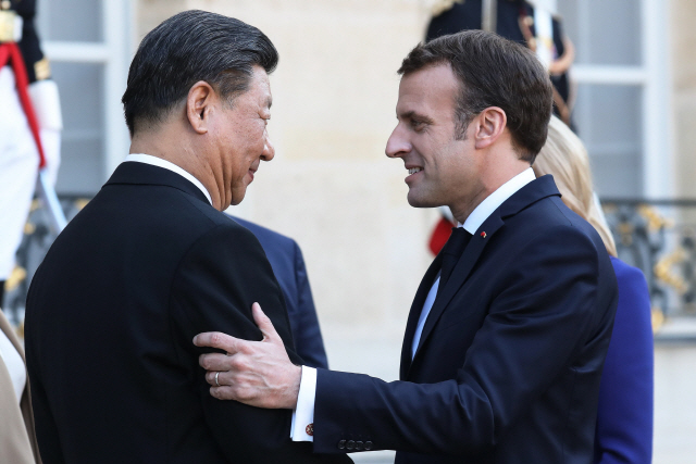 에마뉘엘 마크롱(오른쪽) 프랑스 대통령이 26일(현지시간) 파리 엘리제궁에서 시진핑 중국 국가주석에게 웃으며 이야기하고 있다. /파리=AFP연합뉴스
