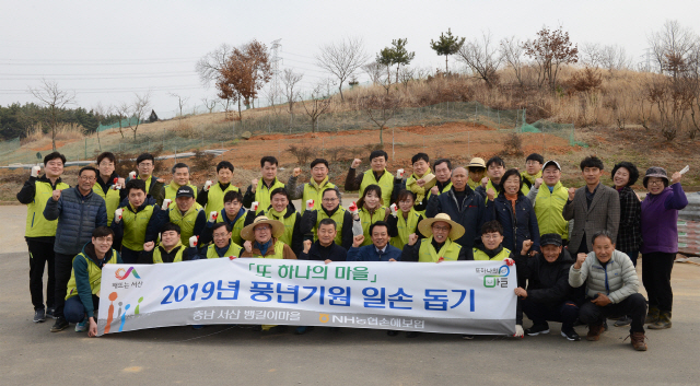 오병관(앞줄 왼쪽에서 네번째) NH농협손해보험 대표이사와 헤아림 봉사단이 27일 김봉배(″ 여섯번째) 서산농협 상임이사, 충남 서산 ‘뱅길이 마을’ 주민들과 파이팅을 외치고 있다. 이날 헤아림 봉사단은 마늘밭 김매기, 마을 환경정비 등 봄철 농번기를 맞아 바쁜 농가에 일손을 보탰다. /사진제공=NH농협손해보험