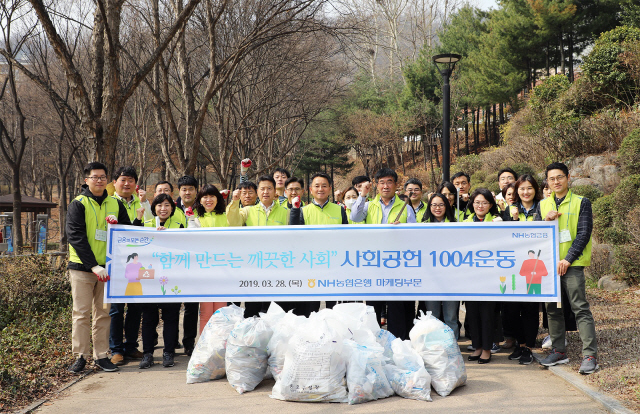 지난 28일 NH농협은행 1004본사단이 서울 서대문독립공원에서 환경정화 봉사활동을 실시했다. 김인태(가운데) 농협은행 부행장 등이 기념사진을 촬영하고 있다./사진제공=농협은행