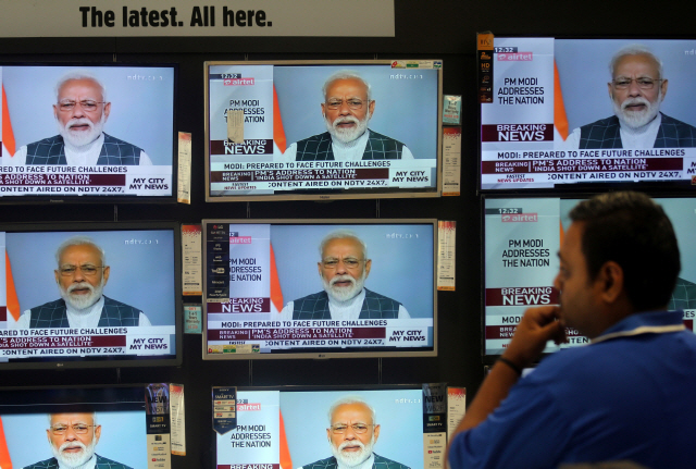 지난 27일(현지시간) 인도 뭄바이에 있는 TV 매장 앞에 한 시민이 저궤도 인공위성 격추 실험에 성공했다는 나렌드라 모디 총리의 TV 담화를 지켜보고 있다./뭄바이=로이터연합뉴스