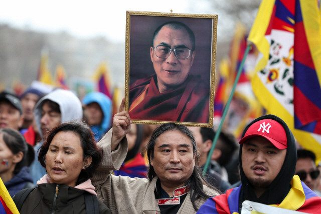 프랑스의 티베트 공동체 사람들이 지난 3월 24일 시진핑 중국 국가주석의 프랑스 방문에 항의하며 달라이 라마의 초상을 들고 파리에서 시위를 진행하고 있다.  /파리=AFP연합뉴스