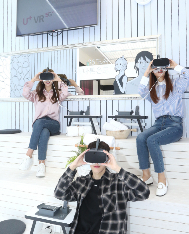 LG유플러스가 1일 서울 강남역 인근에 개장한 U+5G 팝업스토어 ‘일상로5G길’에서 직원들이 가상현실(VR)을 활용해 1인칭 시점으로 웹툰을 보고 있다./사진제공=LG유플러스