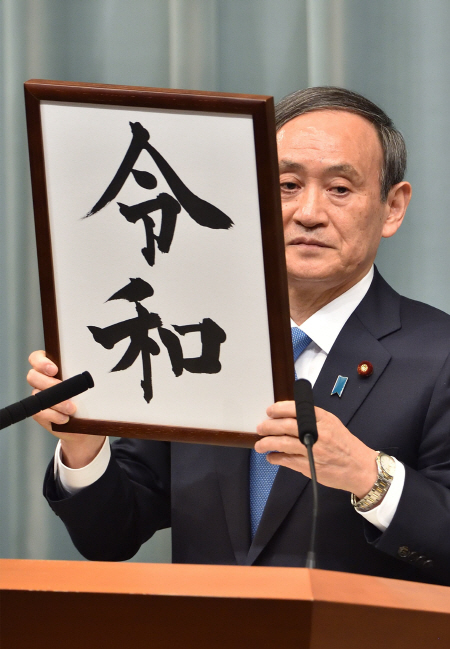 스가 요시히데 일본 관방장관이 1일 도쿄 총리관저에서 오는 5월1일부터 쓰일 새 연호 ‘레이와(令和)’를 발표하며 묵서를 들어 올리고 있다.   /도쿄=AFP연합뉴스
