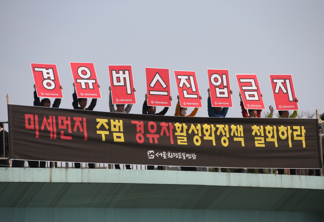 서울의 한 육교 위에서 환경단체 관계자들이 경유버스 진입금지를 촉구하는 캠페인을 하고 있다./연합뉴스