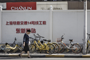 한 여성이 중국의 자전거 공유업체 ‘오포’가 운영하는 자전거 옆을 지나고 있다. /블룸버그