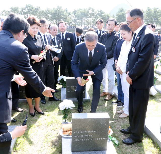 문재인 대통령과 부인 김정숙 여사가 지난해 4월 3일 제주 4ㆍ3 평화공원에서 열린 제70주년 4ㆍ3희생자 추념식에 참석해 행방불명인 묘역에 들러 동백꽃을 헌화하고 있다. /연합뉴스