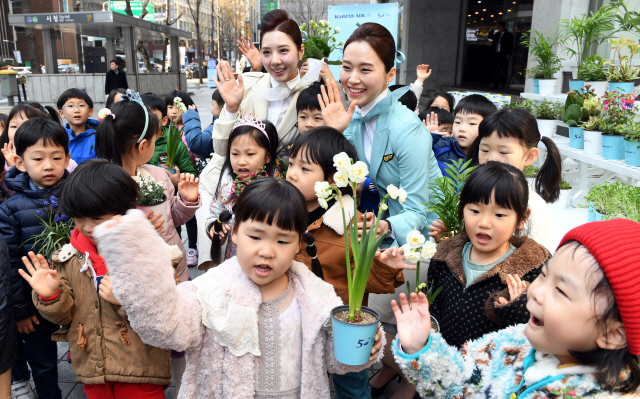 3일 서울 중구 대한항공 서소문 사옥 앞에서 열린 식목일 맞이 화분나눔 행사에서 대한항공 승무원들이 어린이들에게 화분을 증정하고 있다. /이호재기자