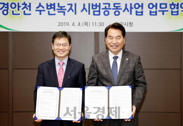 백군기(오른쪽) 용인시장과 나정균 한경유역환경청장이 4일 경안천 수변녹지조성 시범공동사업을 위한 업무협약을 체결하고 기념촬영을 하고 있다. /사진제공=용인시