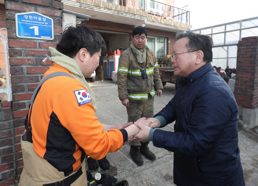 김부겸 행정안전부 장관이 5일 오전 강원도 속초시 장천마을을 찾아 화재진압 작전을 펼친 뒤 잠시 휴식을 취하는 소방대원들을 격려하고 있다. /속초=연합뉴스