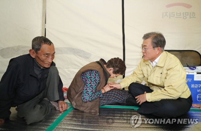 지난 5일 오후 문재인 대통령이 강원도 고성군 토성면 천진초등학교를 방문해 산불로 피해를 겪은 이재민인 장동욱 함상애 씨 부부를 위로하고 있다. /연합뉴스