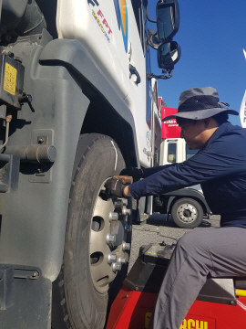 금호타이어 관계자가 고속도로 휴게소에서 대형 트럭 및 버스를 대상으로 타이어 무상 점검 서비스를 실시하고 있다. /사진제공=금호타이어