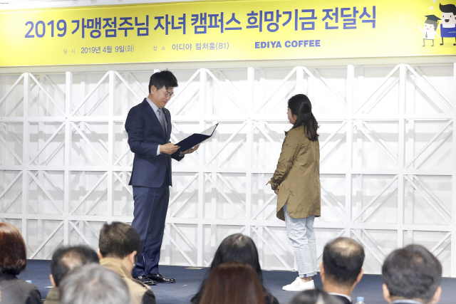 9일 서울 논현동 이디야 본사에서 이디야커피 문창기 회장이 가맹점주 자녀 캠퍼스 희망기금 수여증을 전달하고 있다./사진제공=이디야커피