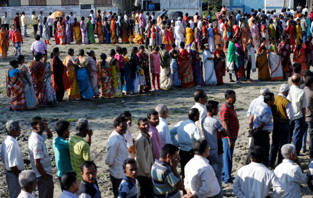 인도가 11일(현지시간)부터 한달간의 총선 일정에 돌입한 가운데 서벵골주 알리푸르두어 지역의 한 투표소에 주민들이 투표하기 위해 길게 줄지어 서 있다.     /알리푸르두어=로이터연합뉴스