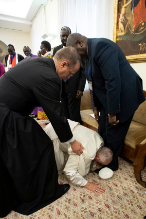 11일(현지시간) 프란치스코 교황이 남수단 지도자 앞에 무릎 꿇고 업드려 발에 입을 맞추고 있다.     /바티칸=로이터연합뉴스