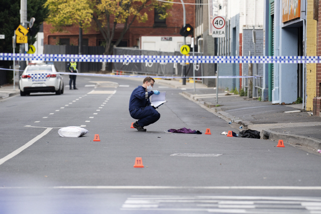 14일(현지시간) 호주 멜버른 프라란 지역의 러브머신 나이트클럽 앞에서 달리는 차량에 의한 총격 사건이 발생한 가운데 경찰이 현장을 조사하고 있다. /멜버른=로이터연합뉴스