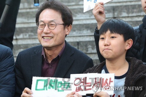 조희연 서울시 교육감이 한 학생과 함께 “미세먼지 없는 세상”이라는 표말을 들고 있는 모습이다./연합뉴스