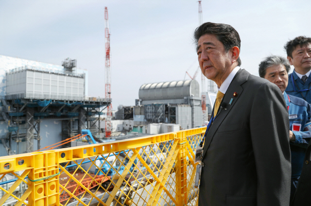 아베 신조(오른쪽 두번째) 일본 총리가 지난 14일 후쿠시마현 오쿠마 소재 후쿠시마 제1 원전을 찾아 관계자들의 설명을 듣고 있다. 아베 총리의 방문은 2013년 9월 이후 약 5년 반 만에 이뤄진 것으로 방호복이 아닌 양복을 입어 방사능 영향이 줄고 있다는 점을 강조했다. /후쿠시마=AP연합뉴스