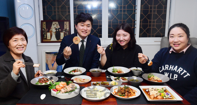 ‘행복한 식탁’에 참여한 강선희씨 부부(가운데)와 친정식구들이 즐겁게 식사를 하고 있다.  /권욱기자