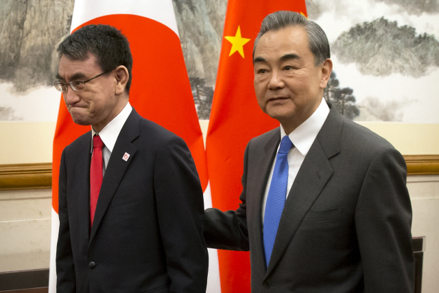 고노 다로(왼쪽) 일본 외상과 왕이 중국 외교담당 국무위원이 지난 15일 베이징에서 함께 회담장으로 이동하고 있다.    /EPA연합뉴스