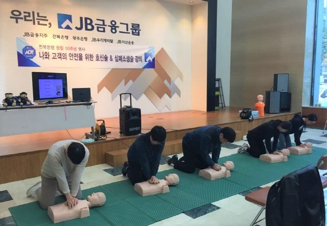 전북 전주의 전북은행 본점 직원들이 ADT캡스 전문요원의 지도를 받으며 심폐소생술을 실습하고 있다. /사진제공=ADT캡스