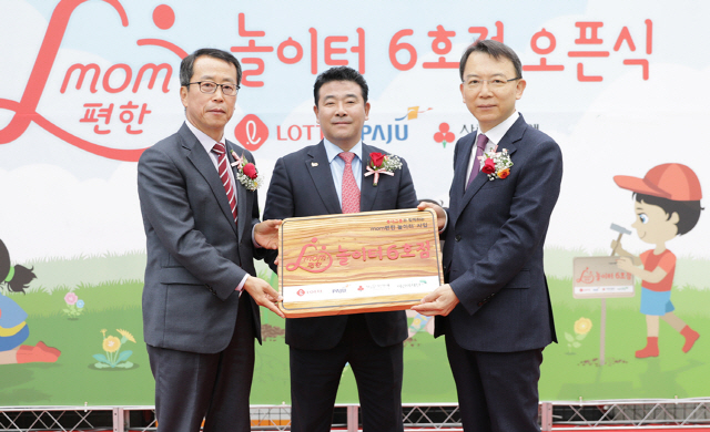 오성엽(오른쪽) 롯데지주 사장이 18일 경기 파주시 금화공원에서 열린 ‘맘(mom) 편한 놀이터’ 6호점 개소식에서 참석자들과 기념촬영을 하고 있다. /사진제공=롯데지주