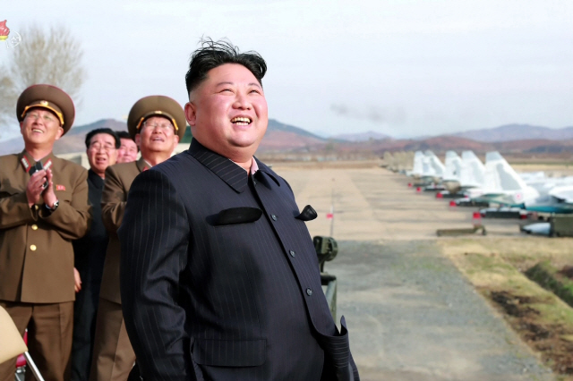 김정은 북한 국무위원장이 지난 16일 공군 제1017군부대 전투비행사들의 비행훈련을 현지 지도하며 흡족한 표정을 짓고 있다. /연합뉴스