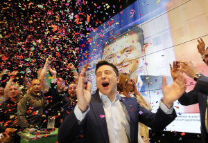 코미디언 출신인 정치 신인 볼로디미르 젤렌스키(가운데)가 21일(현지시간) 치러진 우크라이나 대통령 선거 결선 투표 후 압도적 득표율로 승리할 거란 출구조사가 발표되자 키예프에 있는 선거본부에서 환호하고 있다. 키예프=EPA연합뉴스