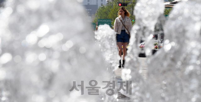 서울의 한낮기온이 28℃까지 오르는 등 초여름 날씨를 보인 22일 서울 광화문광장에서 관광객이 바닥에서 뿜어져 나오는 분수를 바라보며 더위를 식히고 있다./오승현기자 2019.4.22