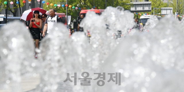 서울의 한낮기온이 28℃까지 오르는 등 초여름 날씨를 보인 22일 서울 광화문광장에서 양산을 쓴 외국인 관광객들이 광장을 걷고 있다./오승현기자 2019.4.22